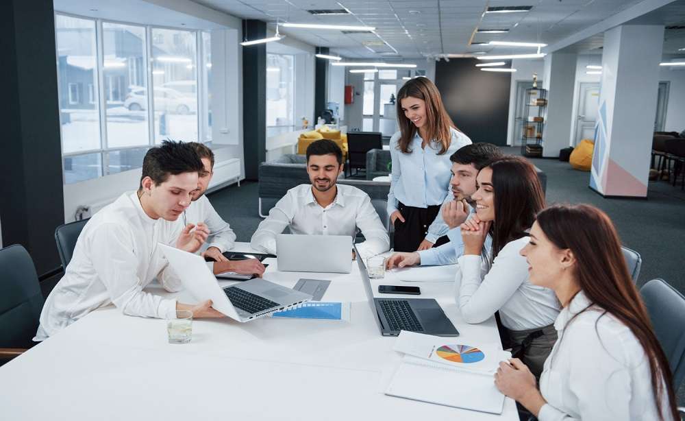 Zoho Book Keeping 2 showing good results group young freelancers office have conversation smiling